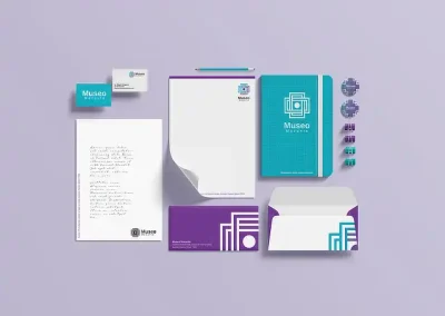 branding empresarial: Identidad visual: tarjetas de presentación, cuaderno de notas, lápices, sobres, pines, libreta con identidad visual del museo Mazunte, todos respetando los colores aqua y morado, utilizando la imagen del logotipo como textura.