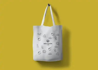 Diseño de identidad visual: para el diseño de la bolsa promocional se decidió colocar alrededor del logotipo los elementos gráficos que acompañan a la marca, que son ilustraciones en línea de Buda, flor de loto, piedras en equilibrio, gota de agua y cuenco. La bolsa es de tela de algodón y la impresión está realizada con tinta negra.
