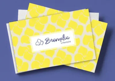 Personalidad de marca: Tarjeta de presentación para Bromelia Lifestyle. La tarjeta tiene un mosaico con flores bromelia color amarillo y encima está el logotipo azul dentro de un rectángulo blanco.